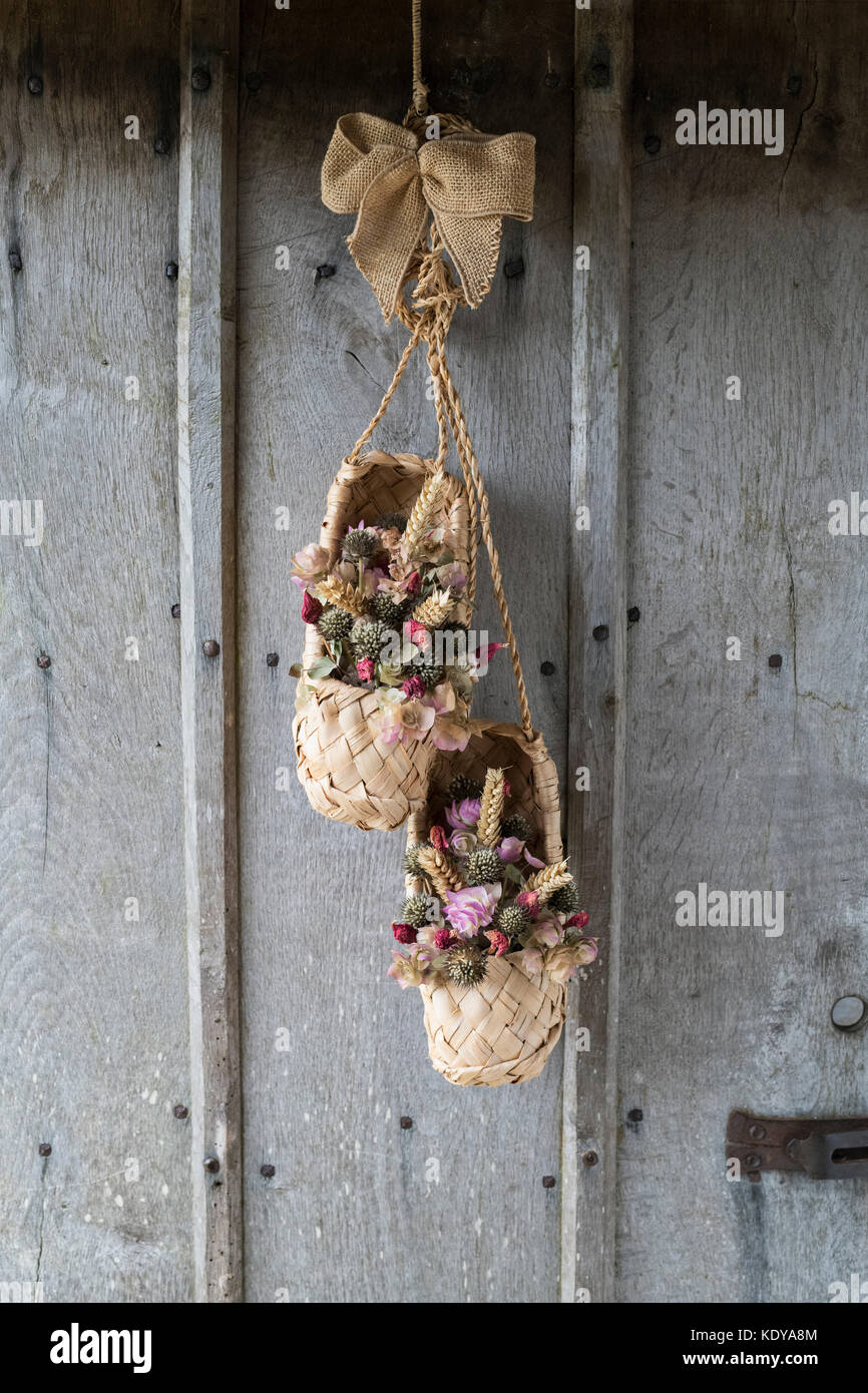 La récolte d'automne festival rustique des paniers de fleurs sur une vieille porte en chêne à Weald et Downland Open Air Museum, automne show, Singleton, Sussex, Angleterre Banque D'Images