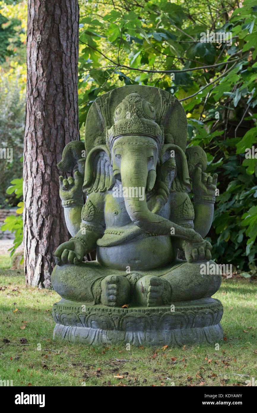Grande pierre ganesha statue dans un jardin anglais. Le Warwickshire, Angleterre Banque D'Images