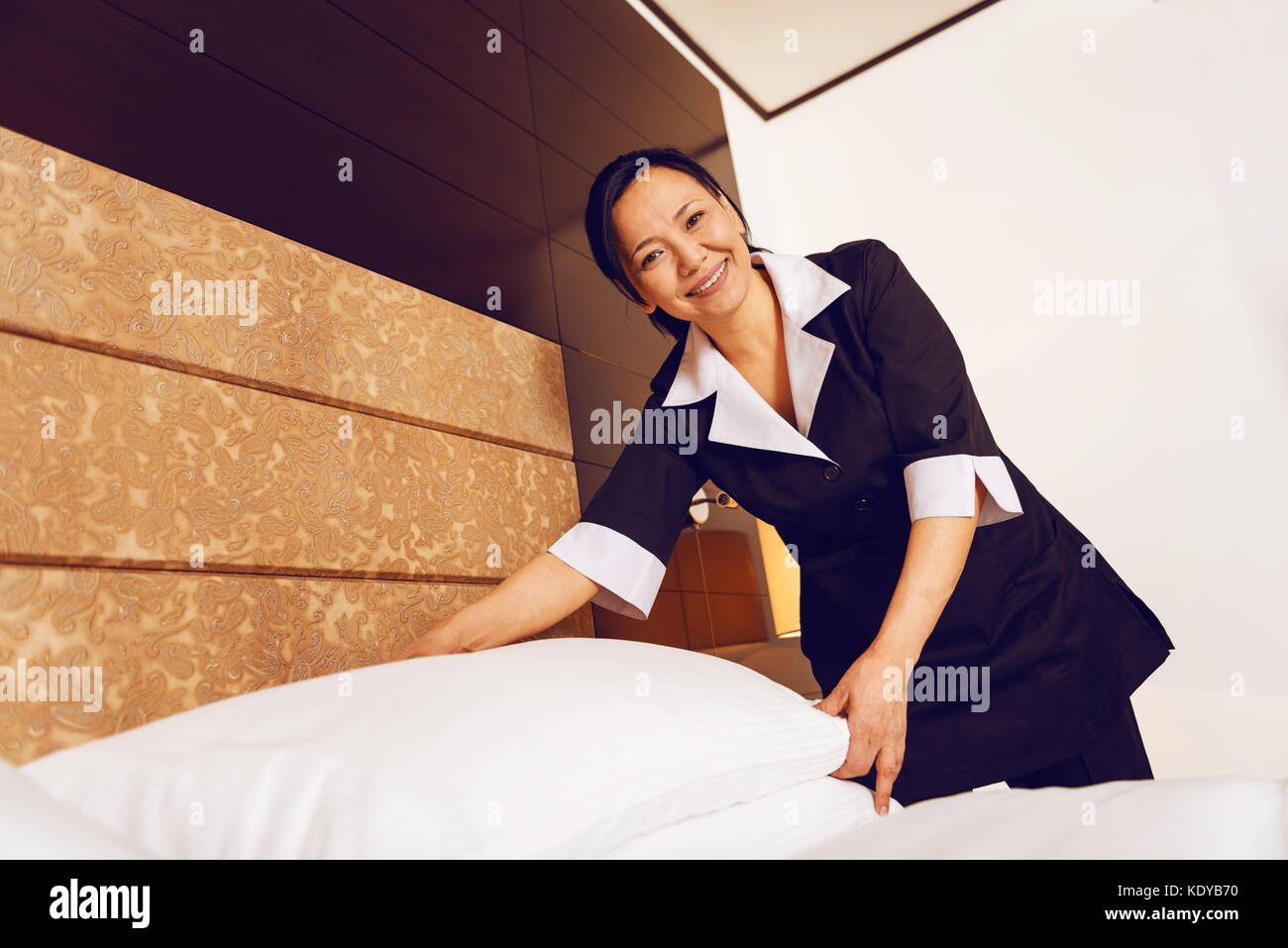 Ravi positive de travail de femme de chambre en chambre luxe Photo