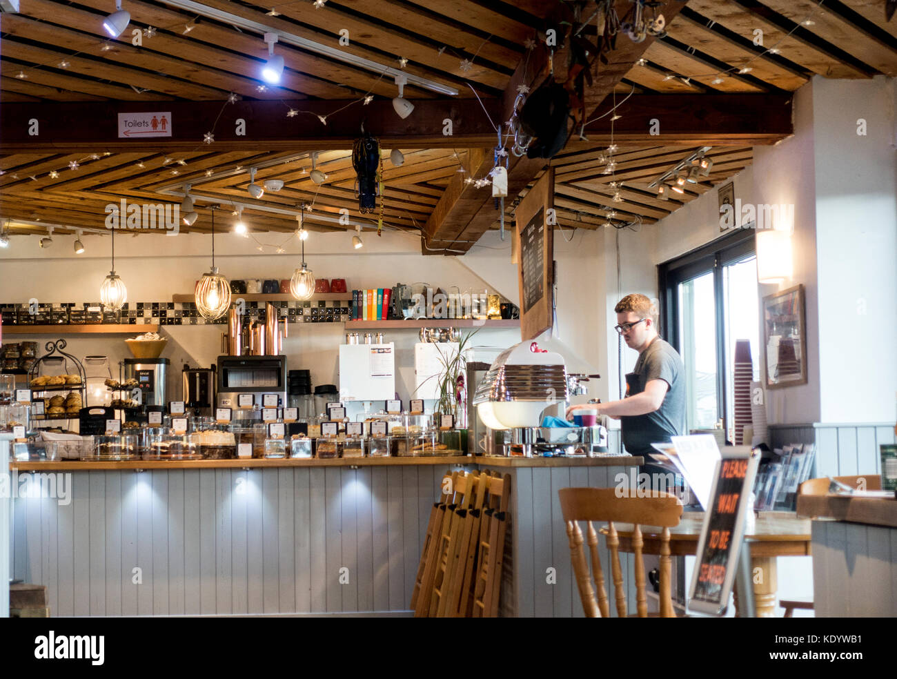 Le café barista au cafe primé le mountain cafe faire le café derrière compteur dans ville balnéaire populaire de Aviemore, Scotland, UK Banque D'Images