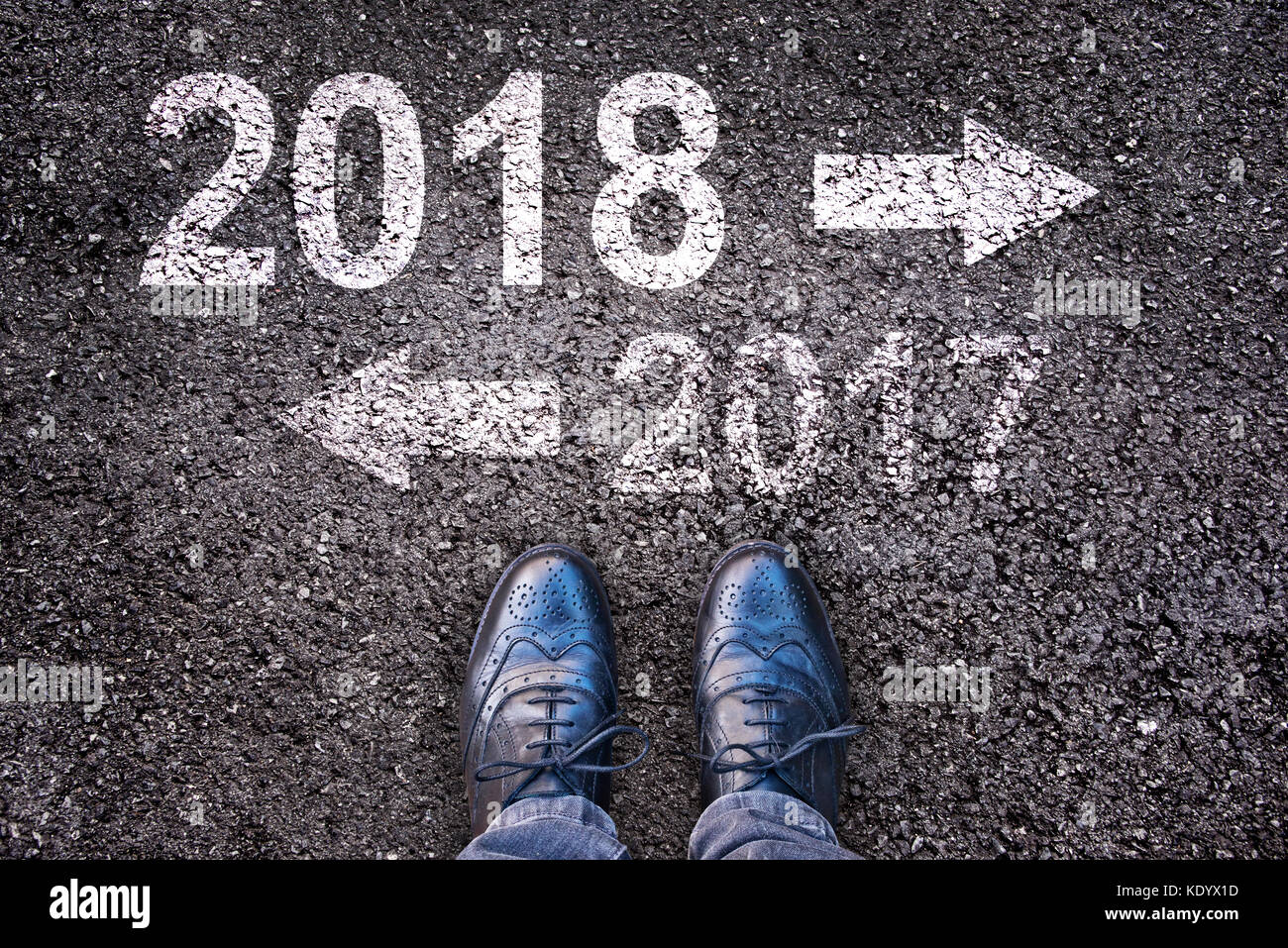 2018 et une flèche écrit sur une route asphaltée, les jambes en arrière-plan Banque D'Images