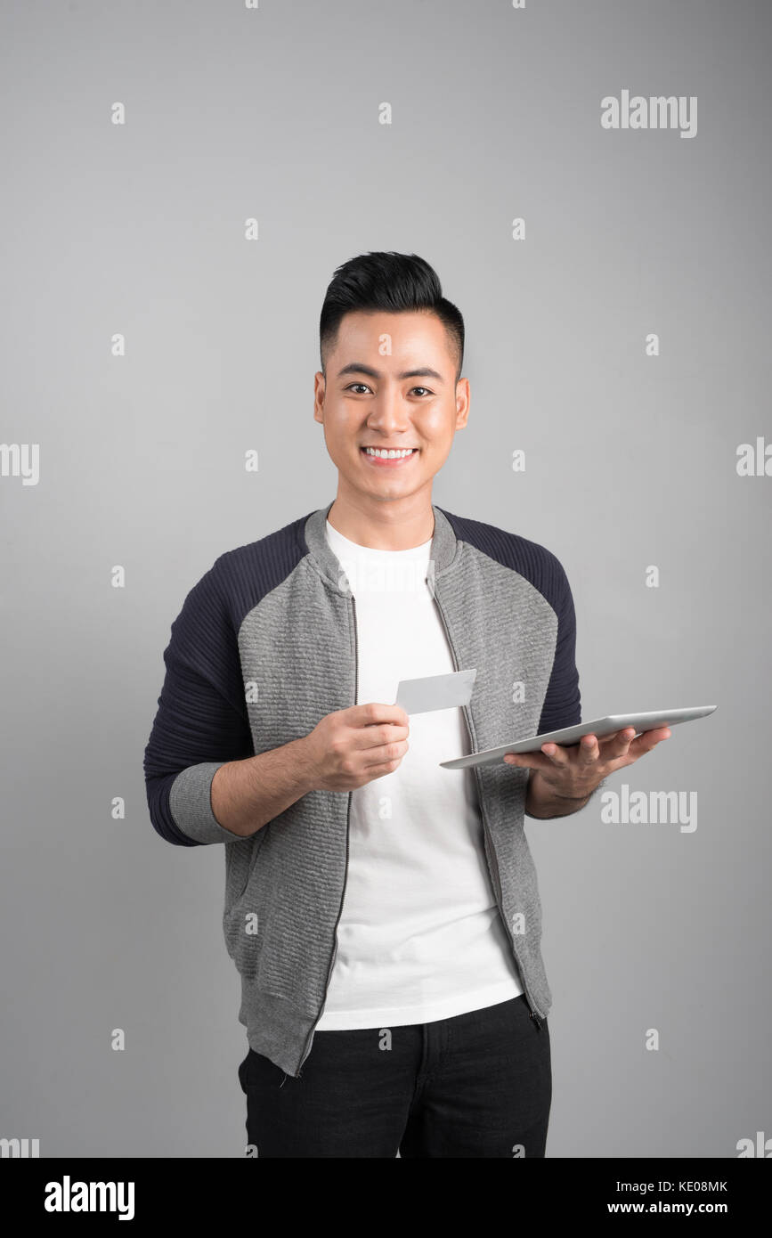 Certains jeunes asian businessman holding digital tablet looking up Banque D'Images