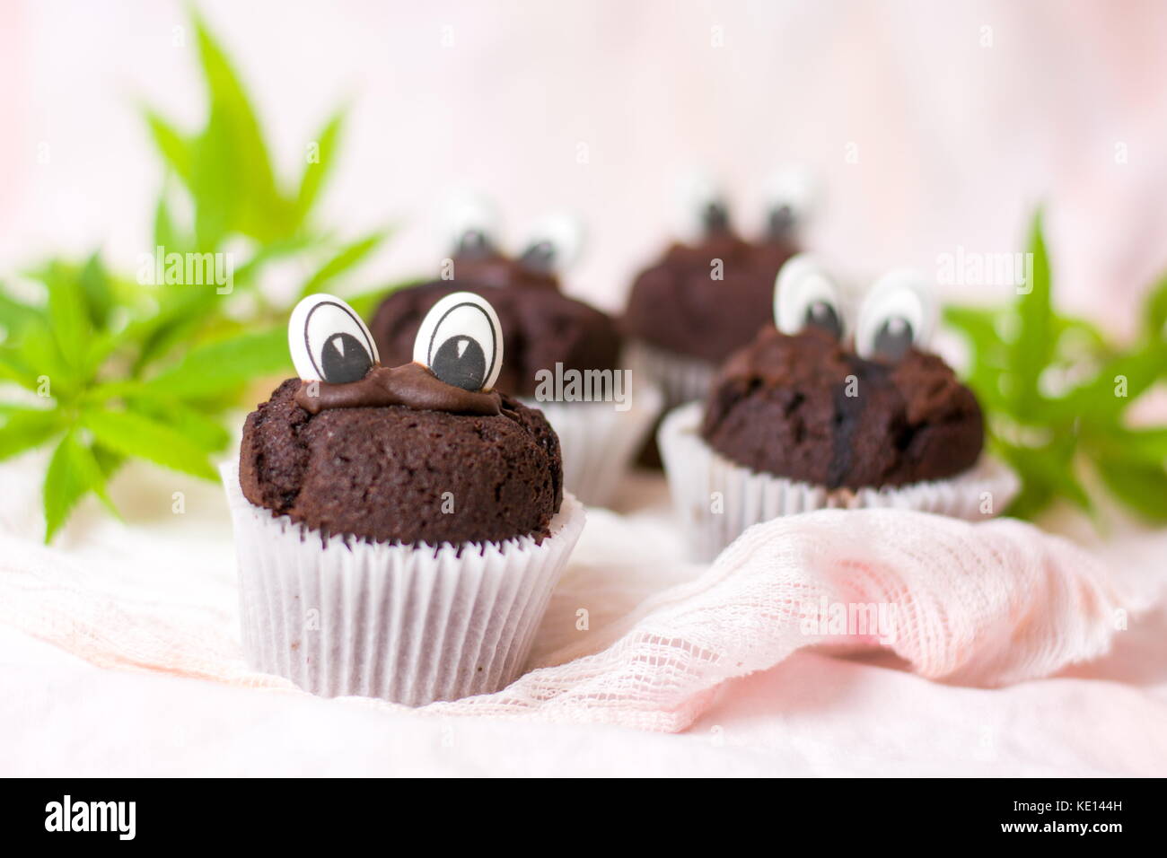 Muffins au chocolat avec de la marijuana et les yeux dans les détenteurs de papier Banque D'Images