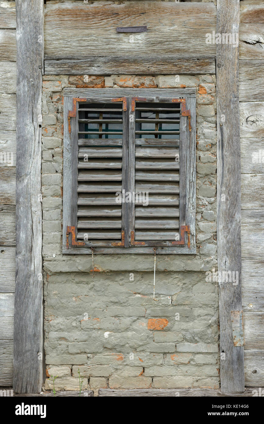 Fenêtre en bois ancien avec des stores en bois sur une maison en bois Banque D'Images