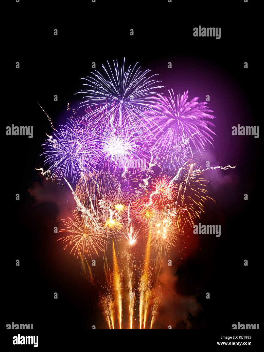 Un grand spectacle de feux d'artifice lumineux avec des roquettes orange dorées et violettes. Banque D'Images