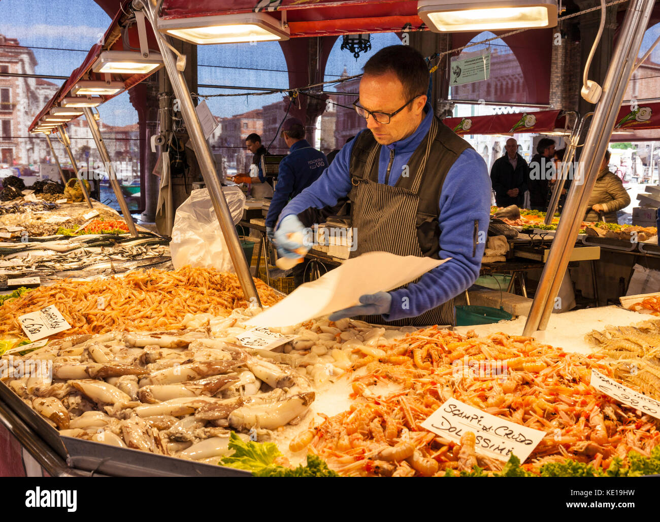 Venise ITALIE VENISE poissonnier la vente de poissons et fruits de mer frais du marché, étals de vente du poisson frais dans le marché du Rialto Venise Italie Europe de l'UE Banque D'Images