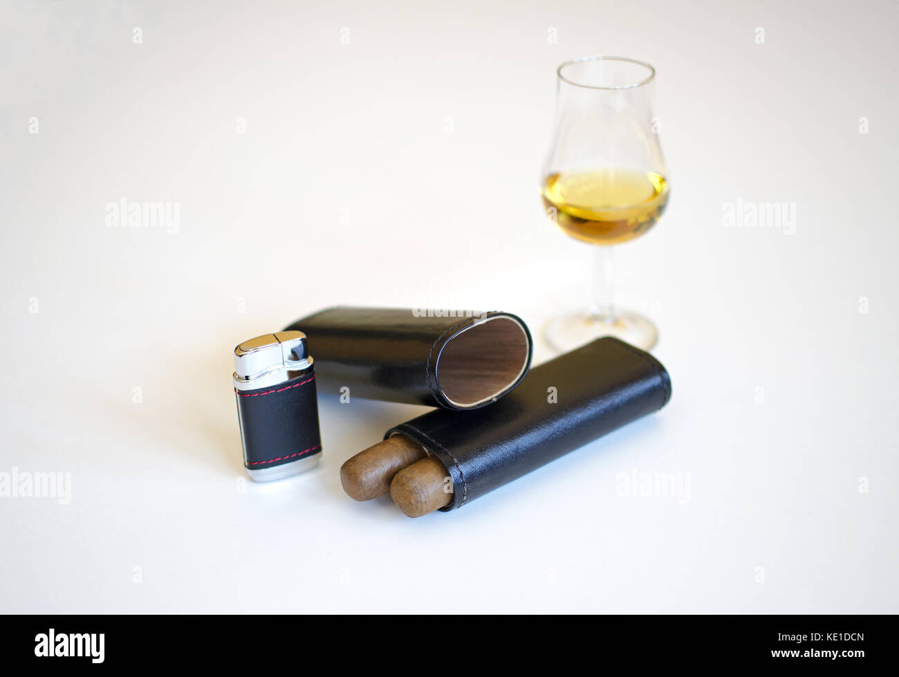 Verre de whisky et deux cigares, cuir, noir, allume-cigares, isolé sur fond blanc Banque D'Images