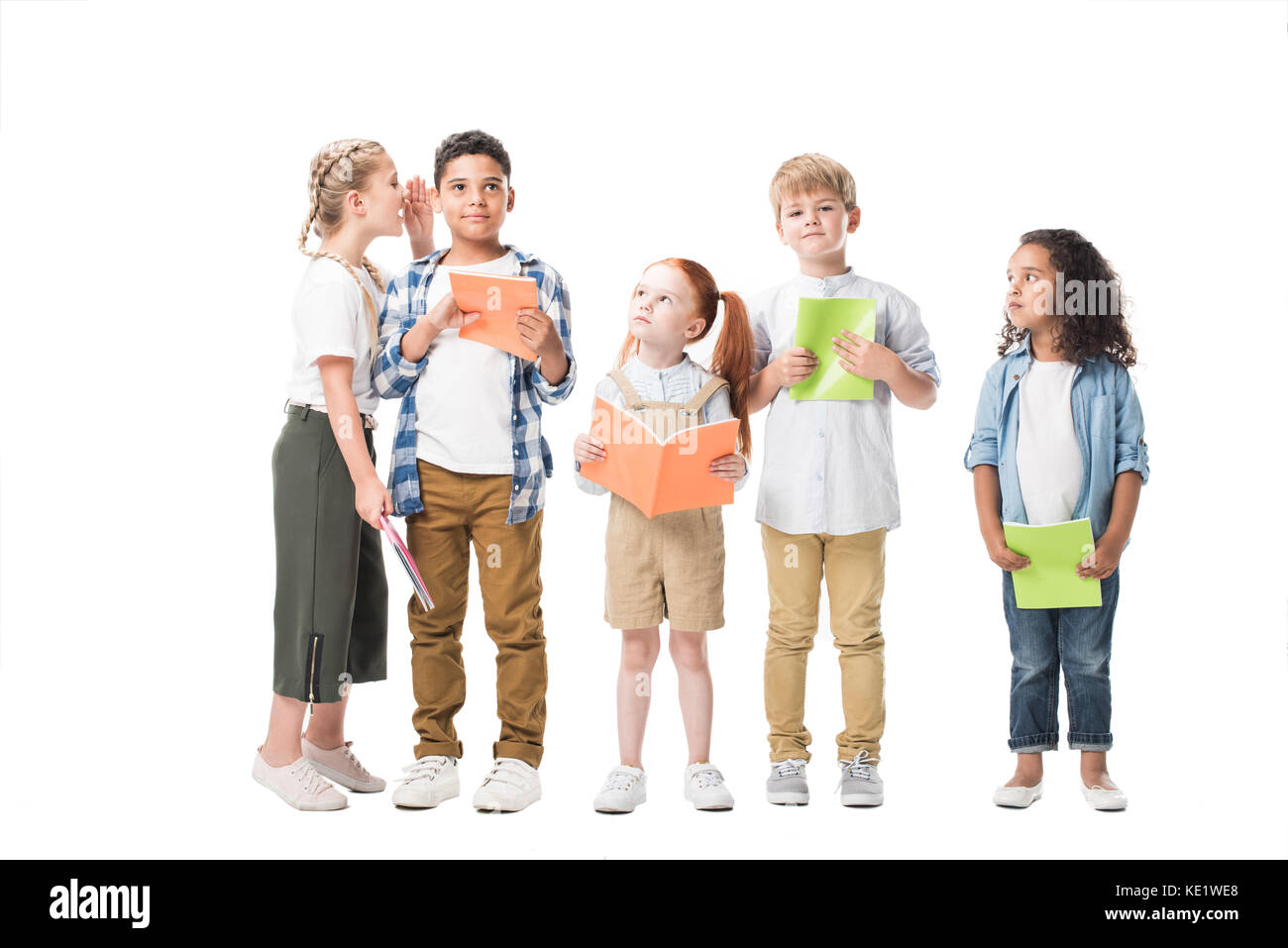 Heureux les enfants multiethnique holding de manuels scolaires et de l'article ensemble isolated on white Banque D'Images