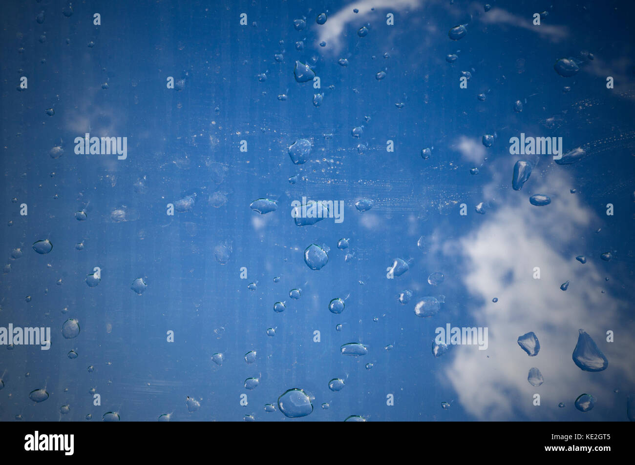 Gouttes d'eau sur le verre sous le ciel. La texture, l'arrière-plan. Banque D'Images