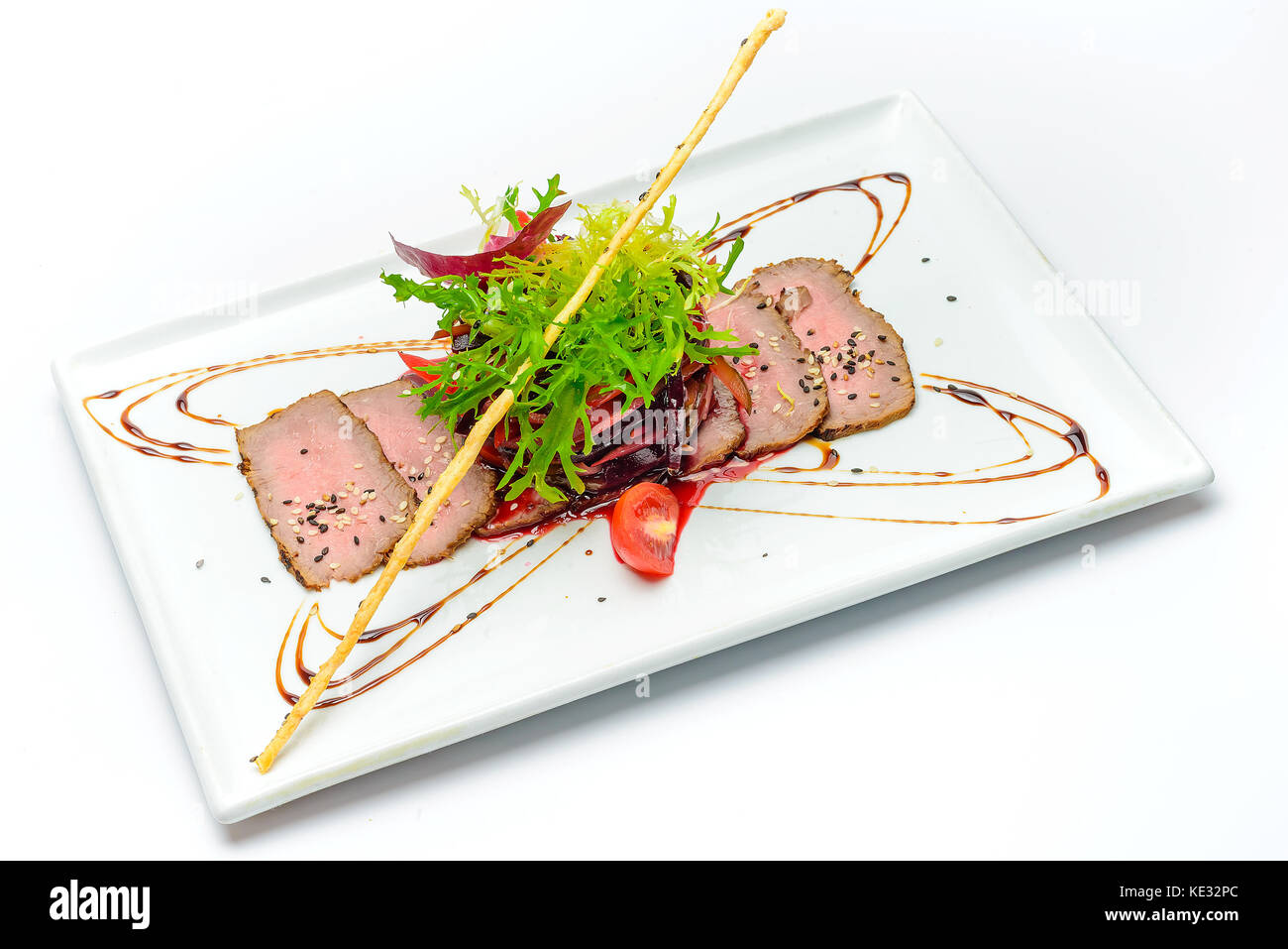 Tranches de viande fraîche sur un plat décoré avec des tomates et de la salade Banque D'Images