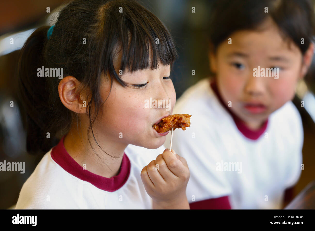 Les enfants japonais de l'école primaire mangent dans la classe Banque D'Images