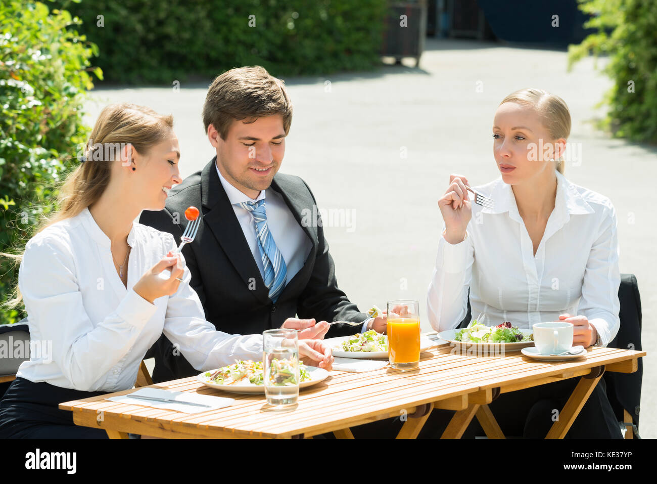 Les jeunes hommes et femmes d'affaires heureux de manger de la nourriture dans le restaurant Banque D'Images