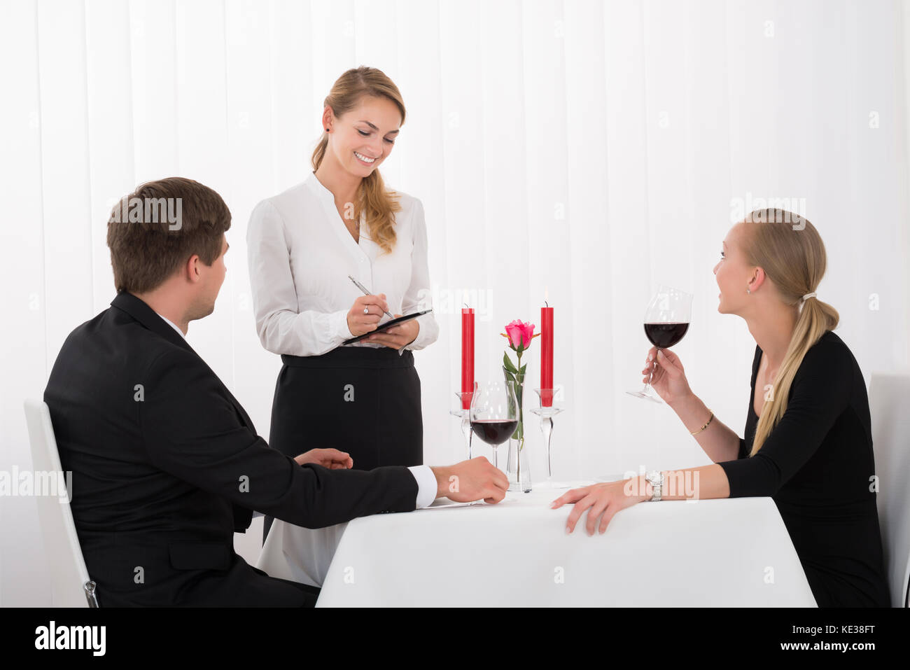 Waitress l'ordre d'un ou deux verre de vin rouge Banque D'Images