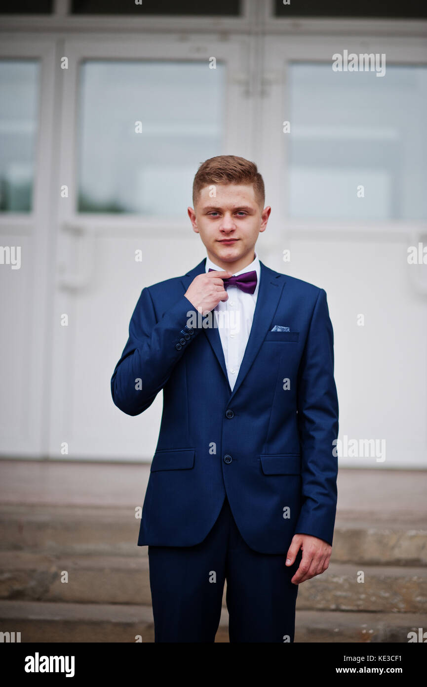 Portrait of a handsome diplômé de l'école secondaire dans l'élégant quartier de tuxedo posant sur l'escalier sur la prom. Banque D'Images