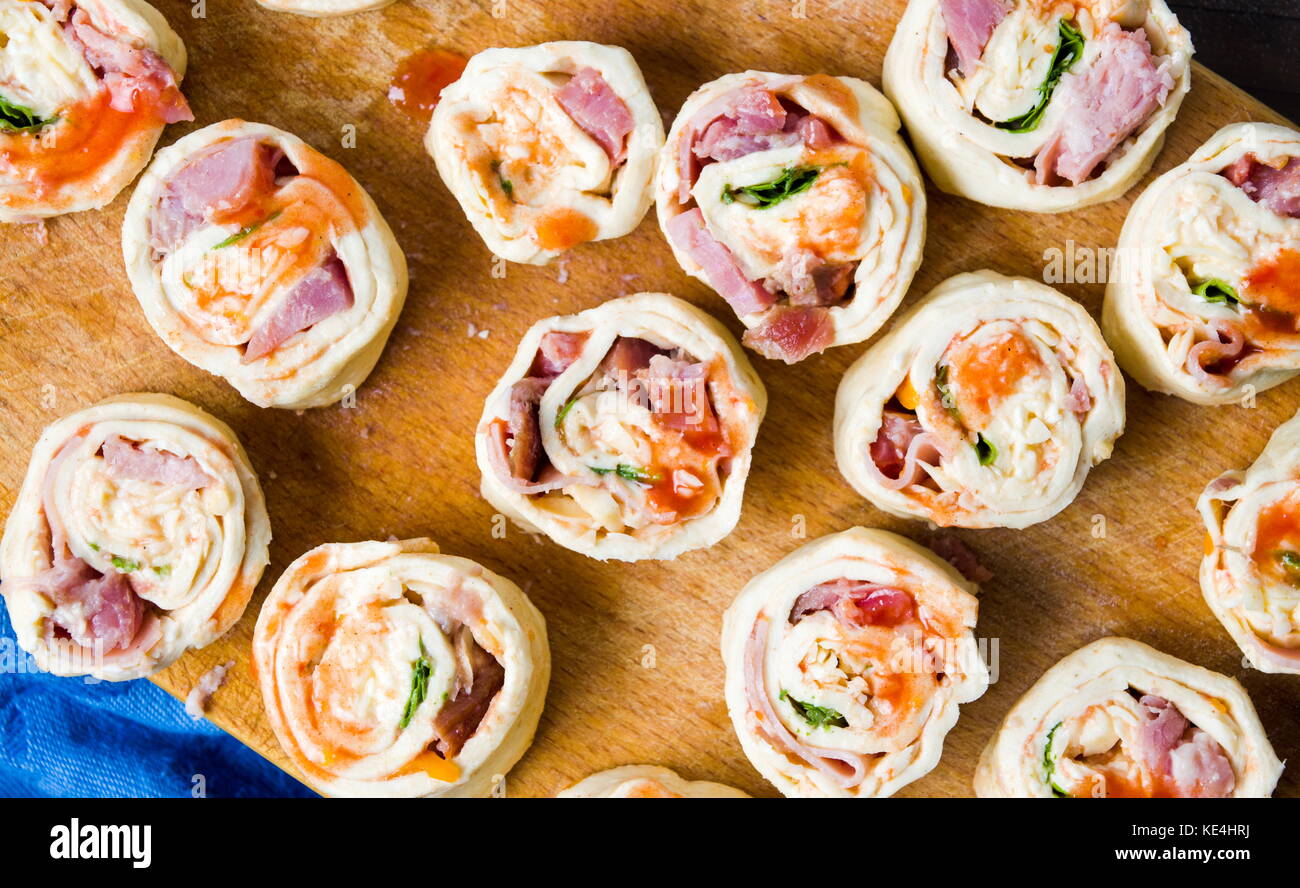 Rouleaux de pizza brut sur une planche à découper en bois Banque D'Images