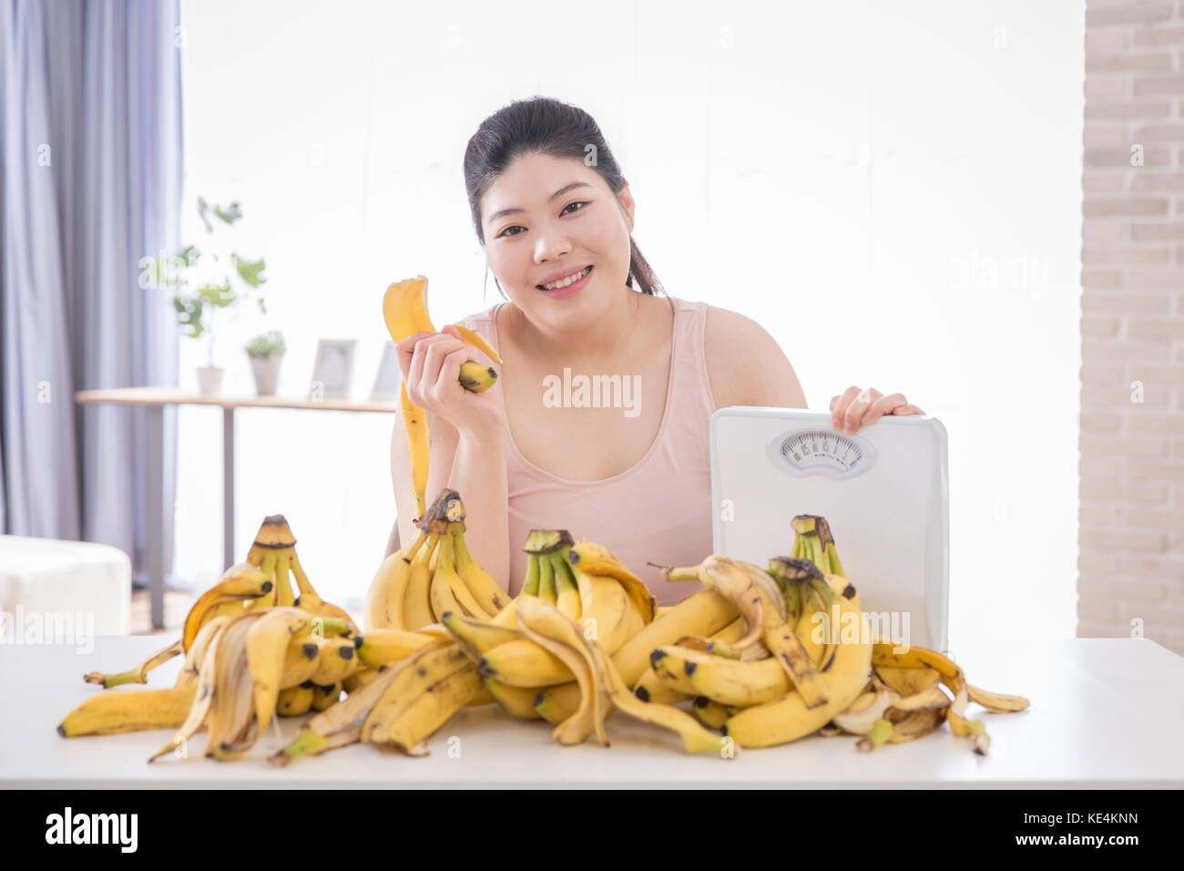 Portrait of young smiling grosse femme avec une échelle et banalité Banque D'Images