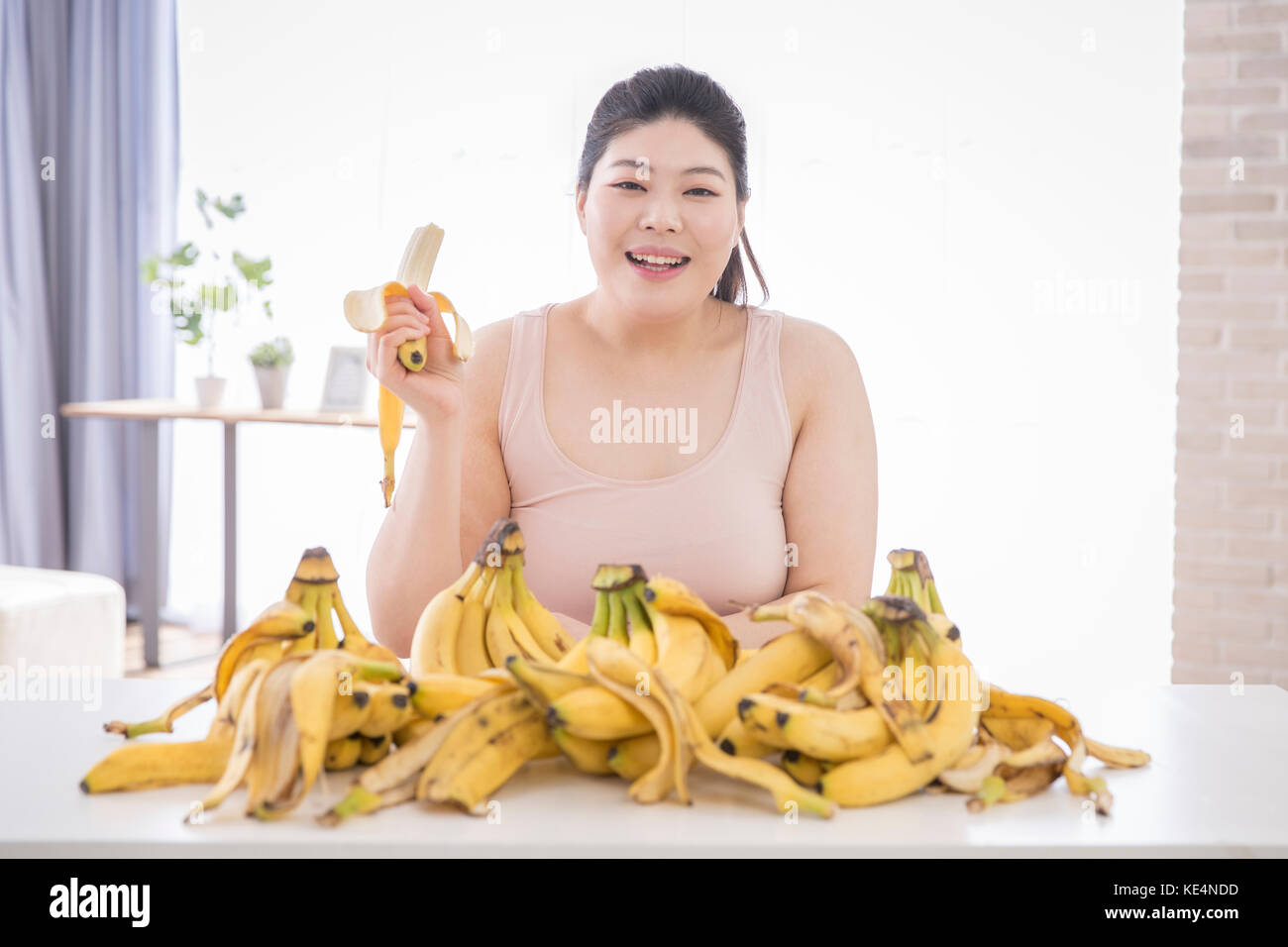 Portrait of young smiling grosse femme avec des bananes Banque D'Images