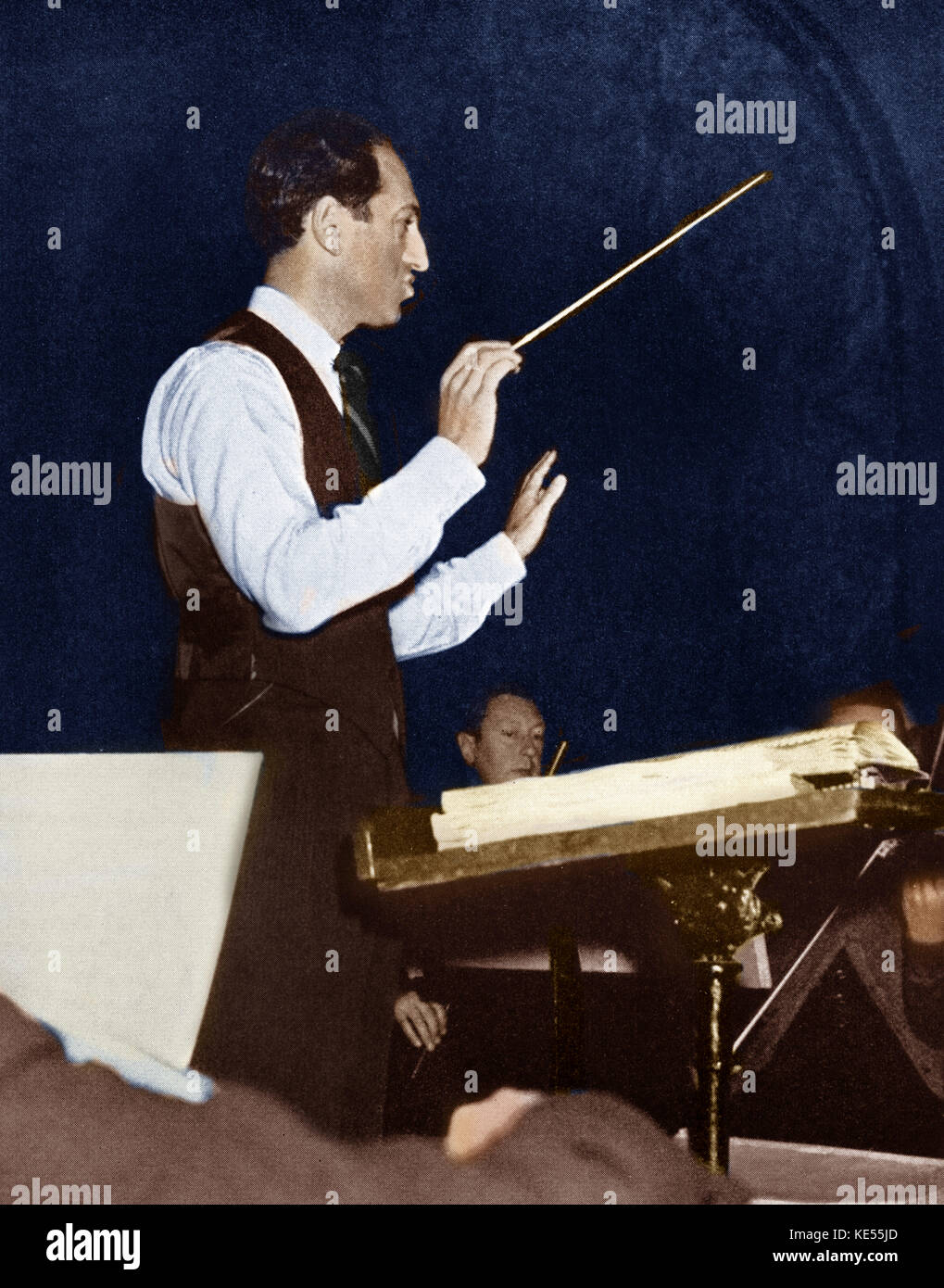 La conduite de George Gershwin avec l'orchestre de répétition . Compositeur et pianiste, 26 septembre 1898 - 11 juillet 1937. Version colorisée. Banque D'Images