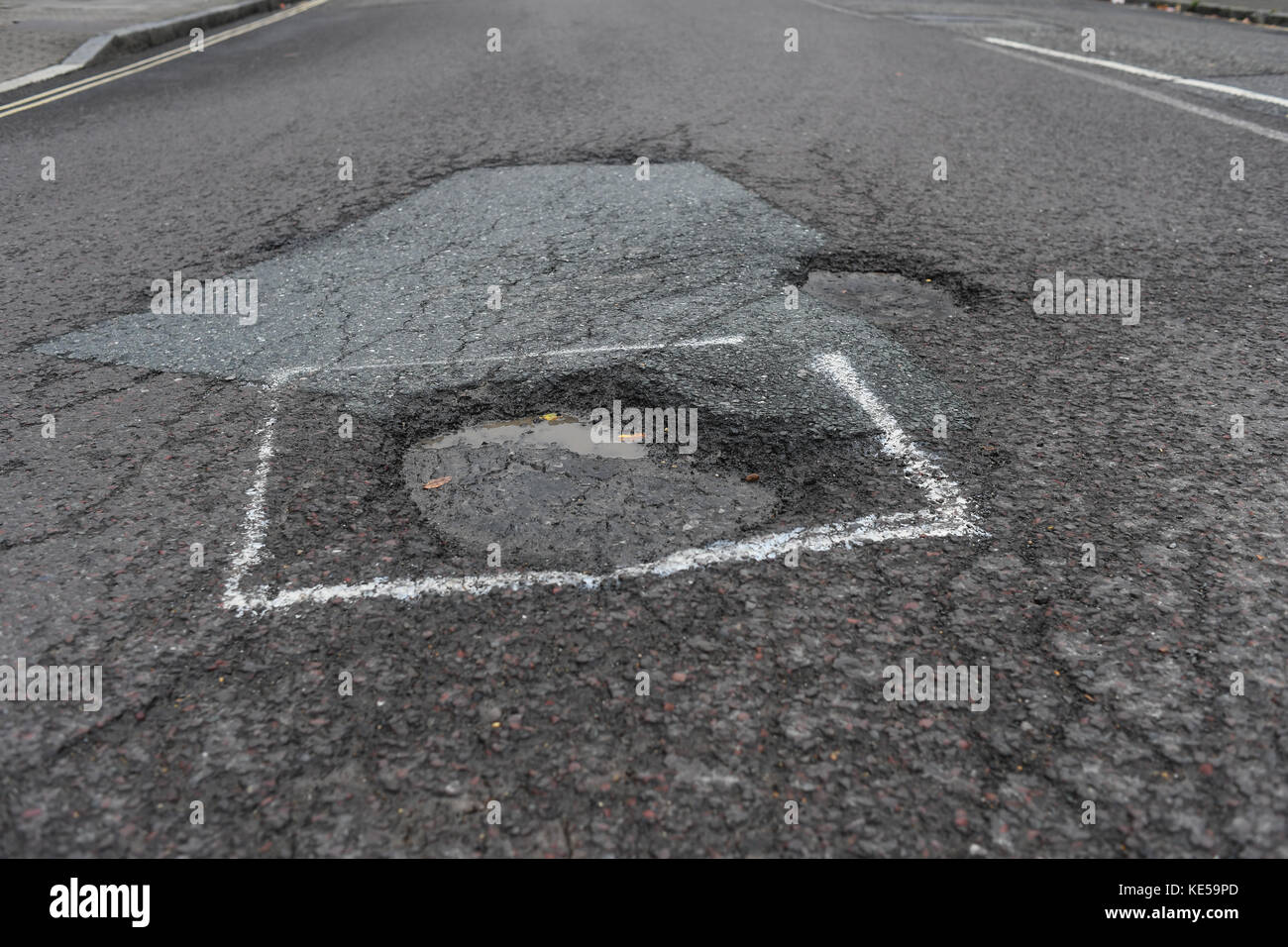 En fondrières road causant la misère pour automobiliste Banque D'Images