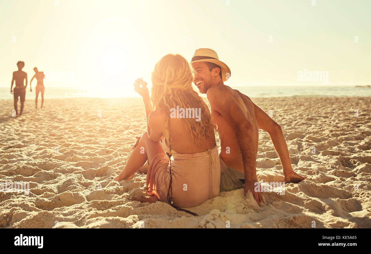 Jeune couple se détendant sur la plage ensoleillée d'été Banque D'Images