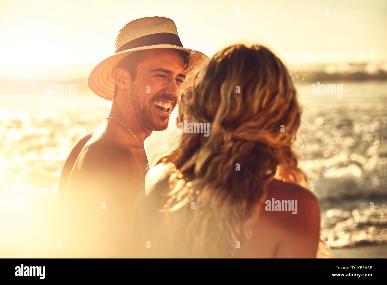 Rire jeune couple sur la plage ensoleillée d'été Banque D'Images