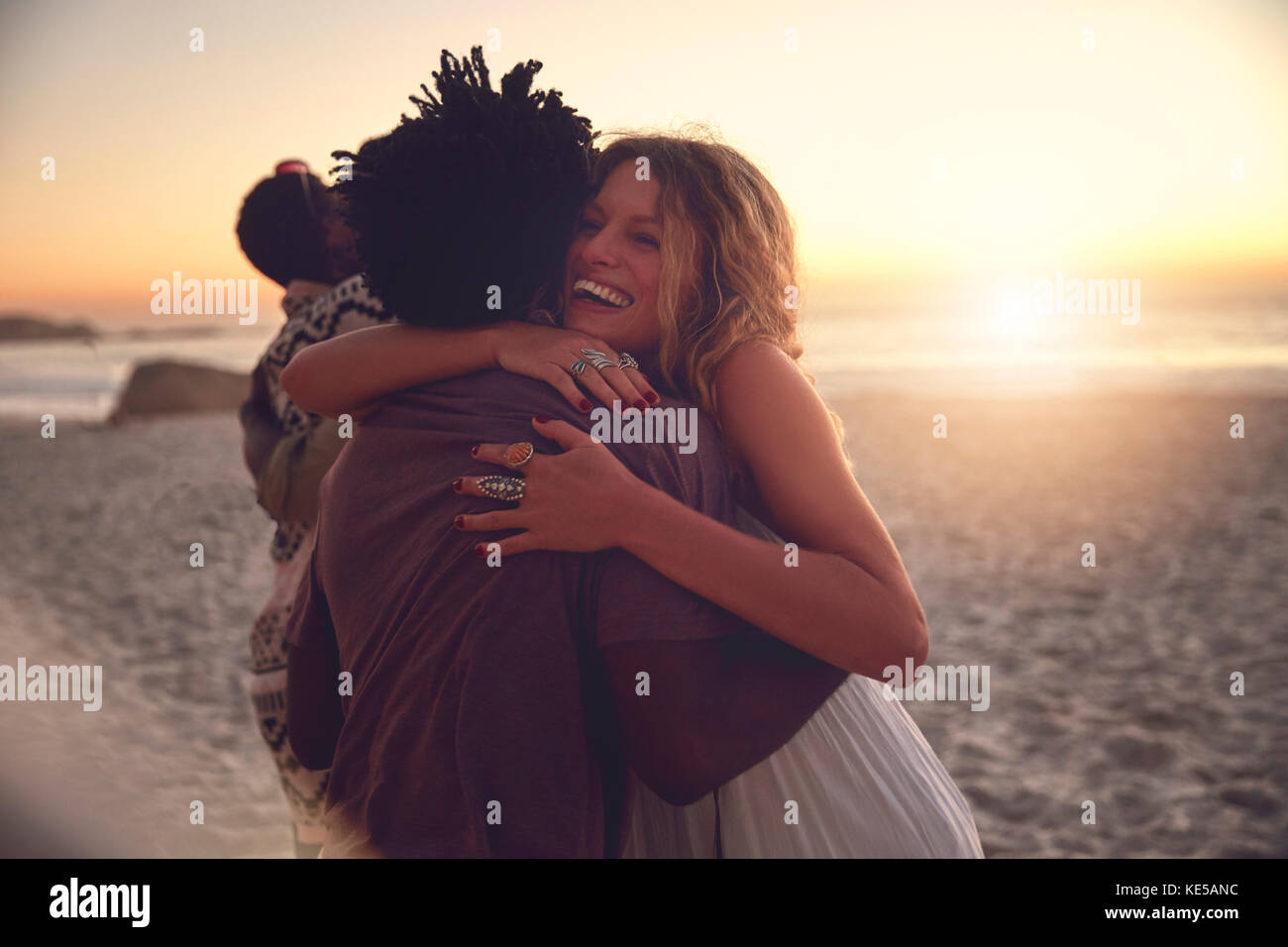 Couple affectueux qui s'embrasse sur la plage ensoleillée d'été au coucher du soleil Banque D'Images