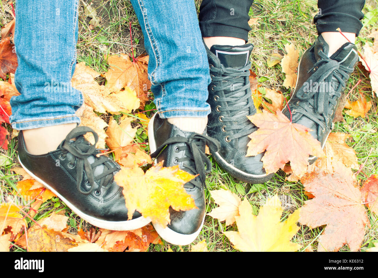 Deux filles chaussures sur les feuilles d'automne, vue du dessus, qu'il photo Banque D'Images