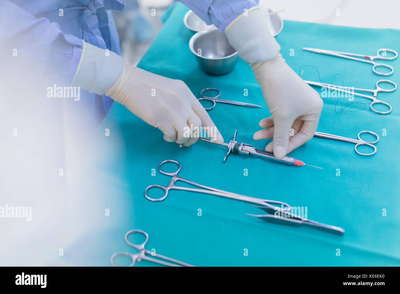 Chirurgien portant des gants en caoutchouc pour préparer les instruments chirurgicaux sur le plateau Banque D'Images