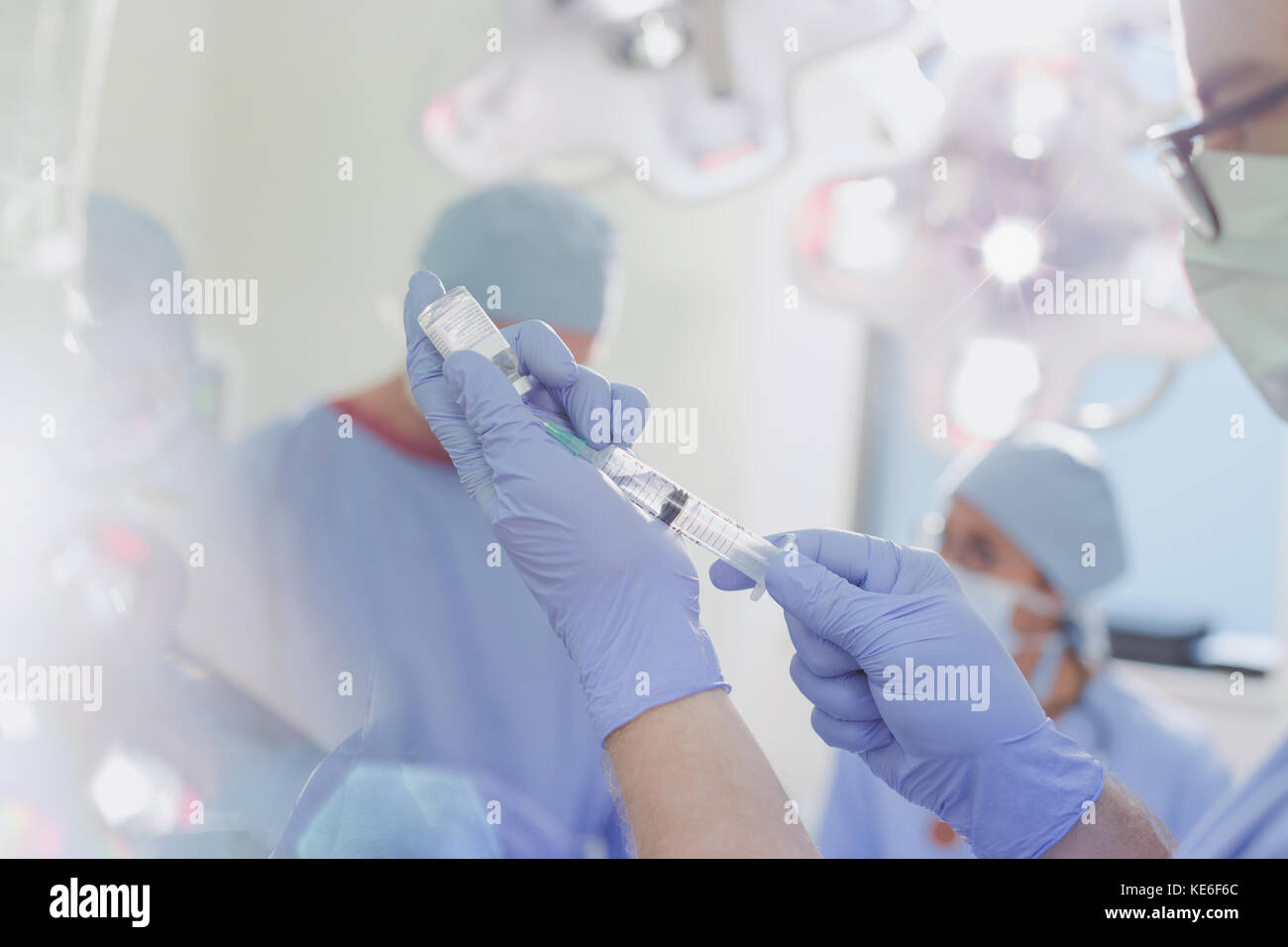 Anesthésiste masculin avec seringue préparant le médicament d'anesthésie en salle d'opération Banque D'Images