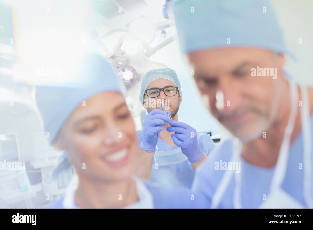 Anesthésiologiste masculin préparant le médicament d'anesthésie dans la seringue dans la salle d'opération Banque D'Images