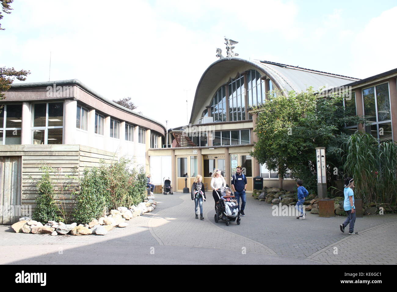 Les personnes qui visitent le zoo de Blijdorp de Rotterdam, aux Pays-Bas. L'arrière du Rivierahal monumental, conçu par l'architecte Sybold van Ravesteyn Banque D'Images