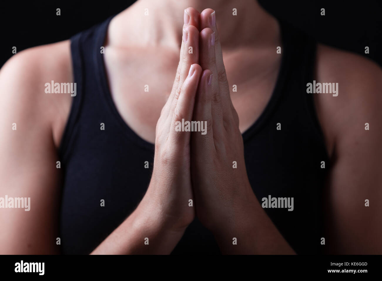 Mains d'une femme fidèle priant, les mains croisées, paumes ensemble dans l'adoration de Dieu / prier la prière fidèle close up closeup adoratrice du culte chrétien Banque D'Images