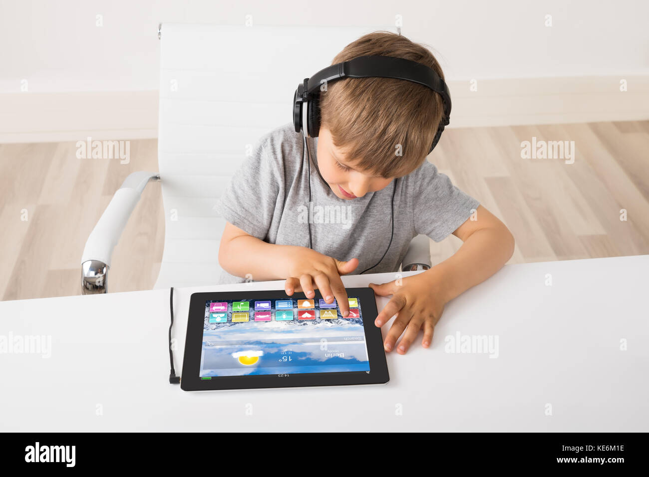 Boy Listening Music sur tablette numérique multicolore avec des apps sur elle Banque D'Images