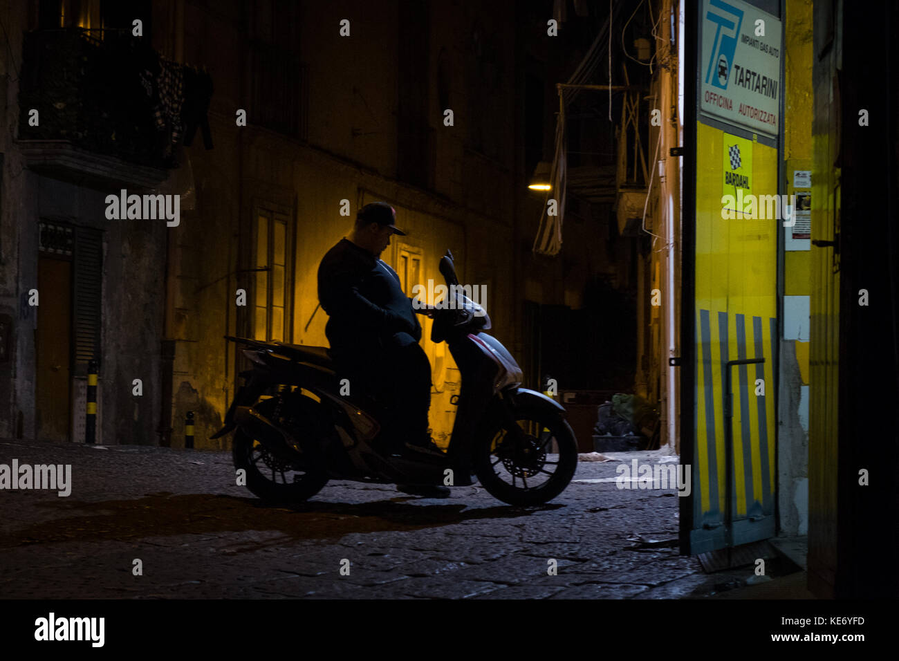 Garçon avec un scooter scooter pour mettre en attente en parking Banque D'Images