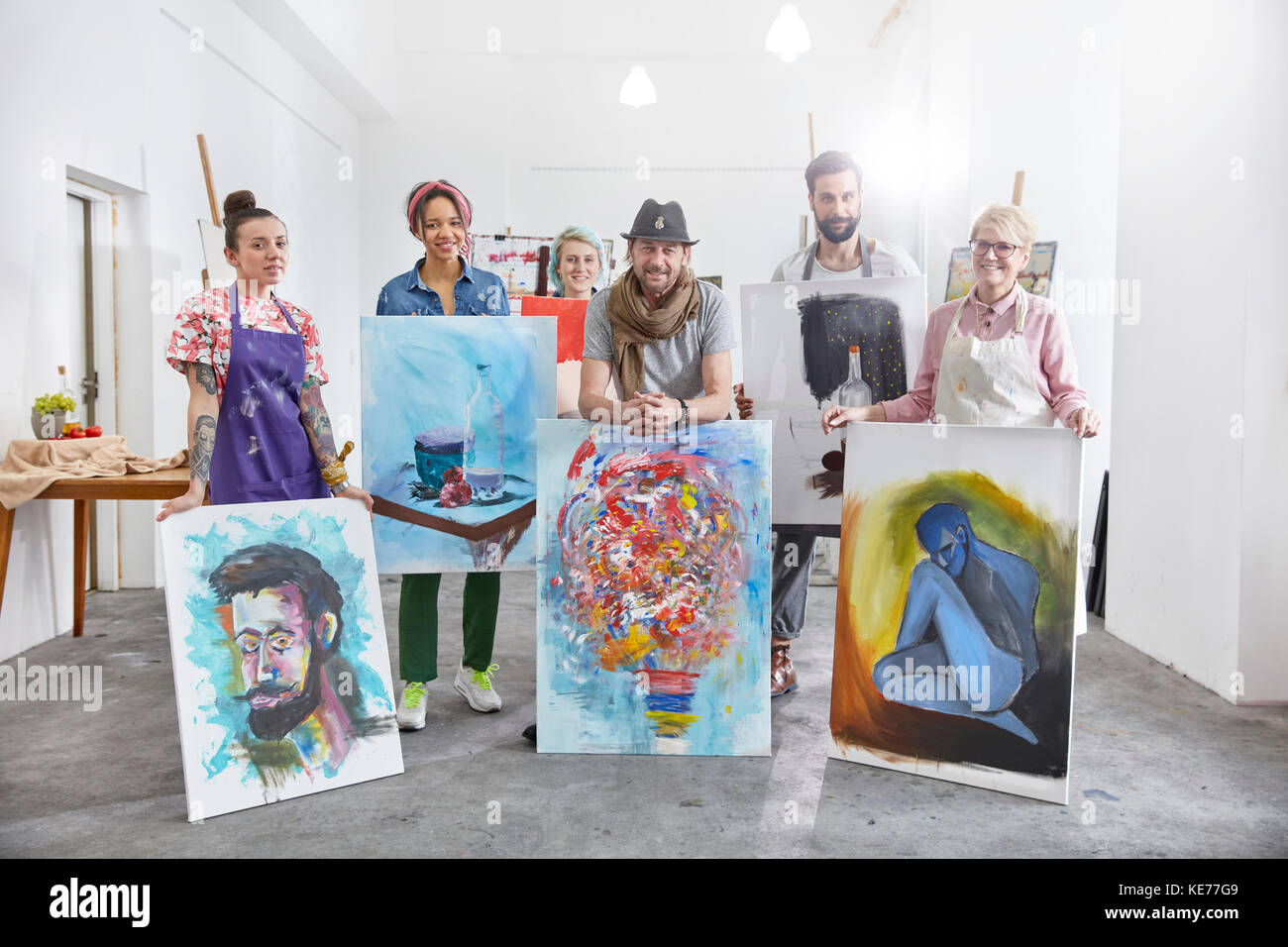 Portraits d'artistes sûrs montrant des peintures dans un studio de classe artistique Banque D'Images