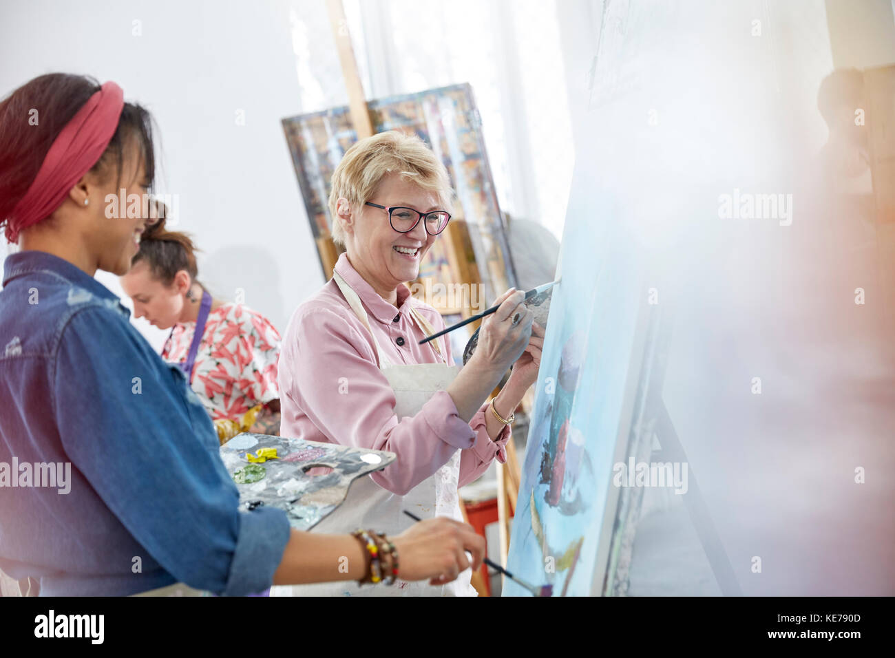 Des artistes féminins peignant dans un studio de classe d'art Banque D'Images