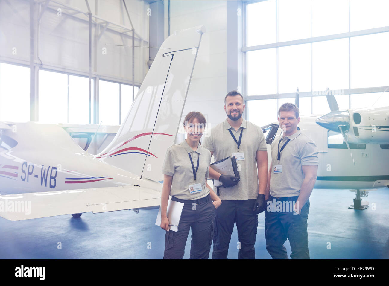 Les ingénieurs mécaniciens Portrait confiant dans le hangar avion permanent Banque D'Images