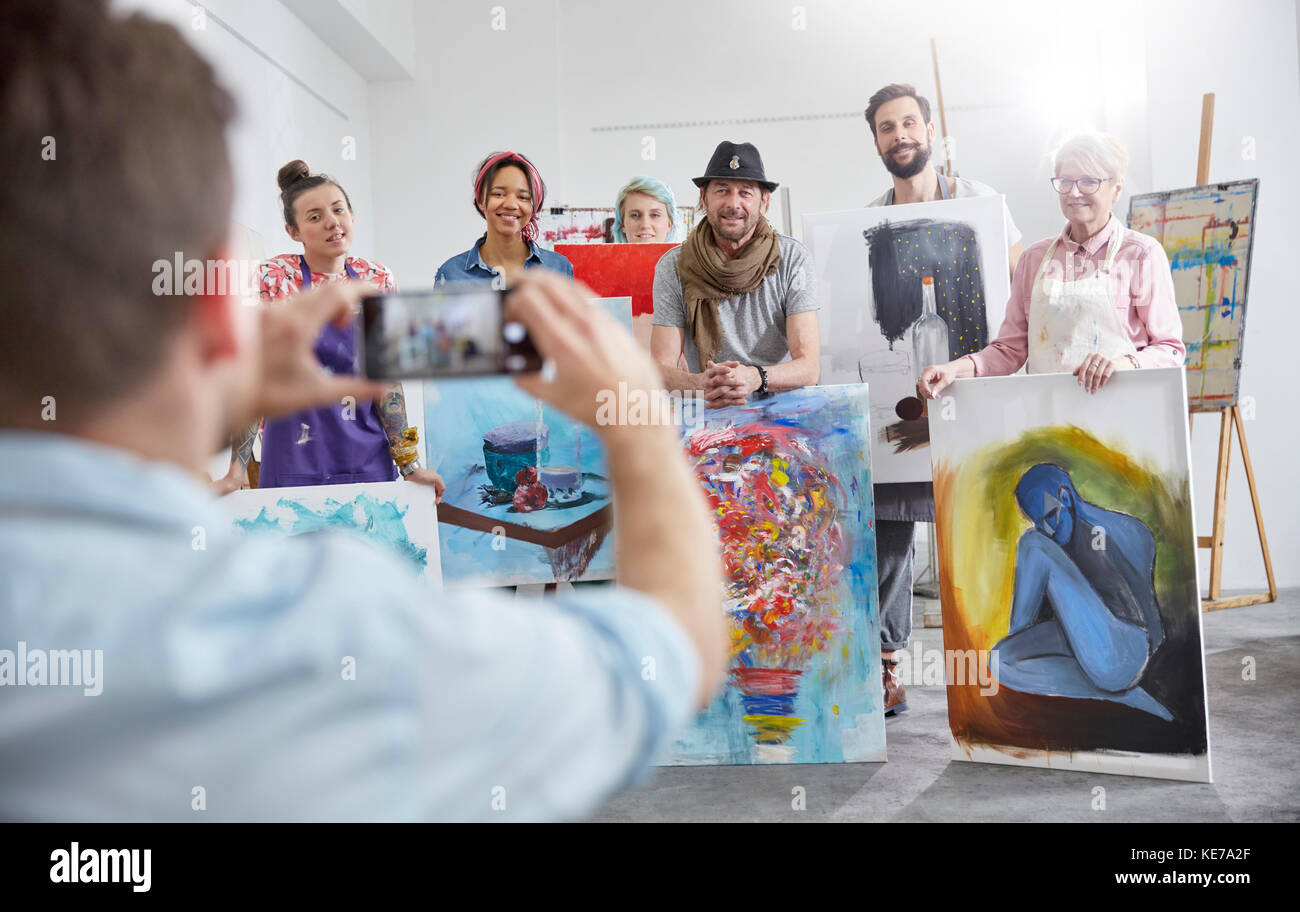 Homme photographiant des camarades de classe dans un studio d'art Banque D'Images