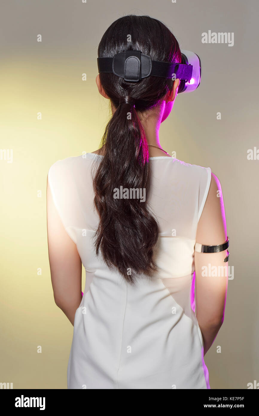Dos de jeune femme avec casque de réalité virtuelle Banque D'Images