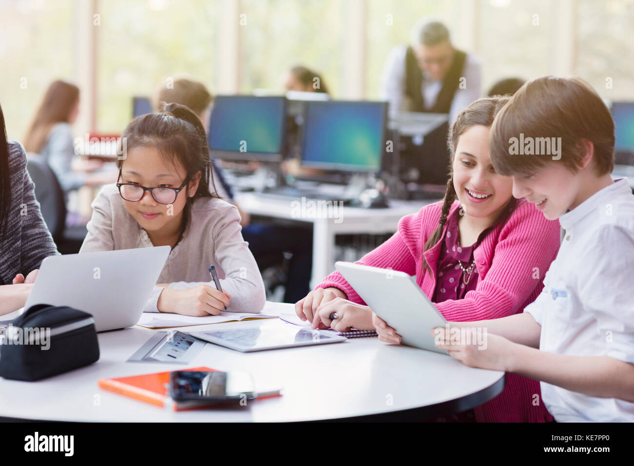 Étudiants utilisant une tablette numérique et un ordinateur portable dans une bibliothèque Banque D'Images