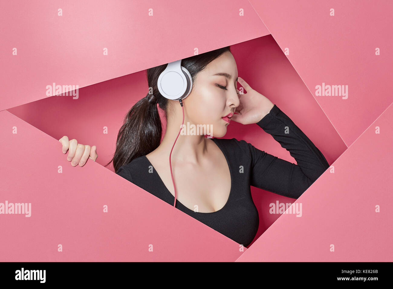 Vue de côté portrait of young woman listening to music Banque D'Images