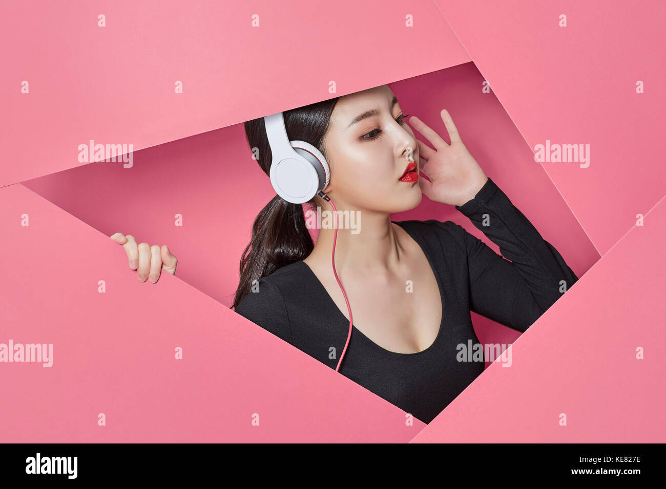 Vue de côté portrait of young woman listening to music Banque D'Images