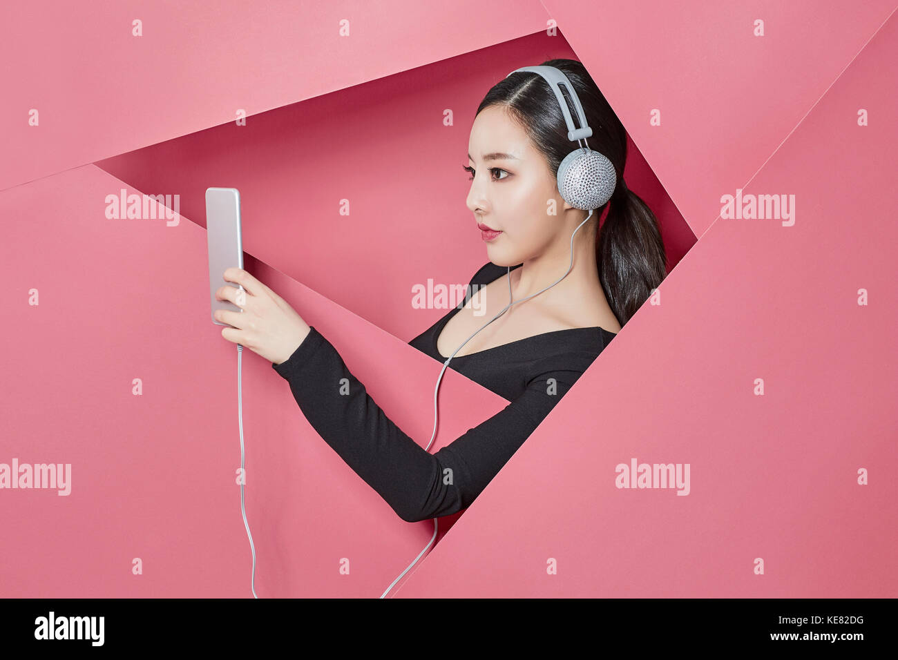 Side view portrait of young woman listening to music on smartphone Banque D'Images