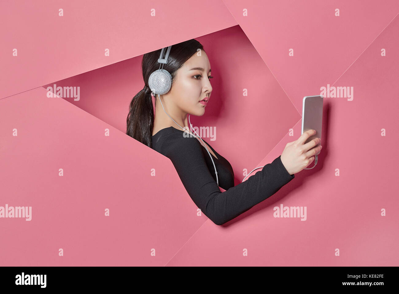 Side view portrait of young woman listening to music on smartphone Banque D'Images
