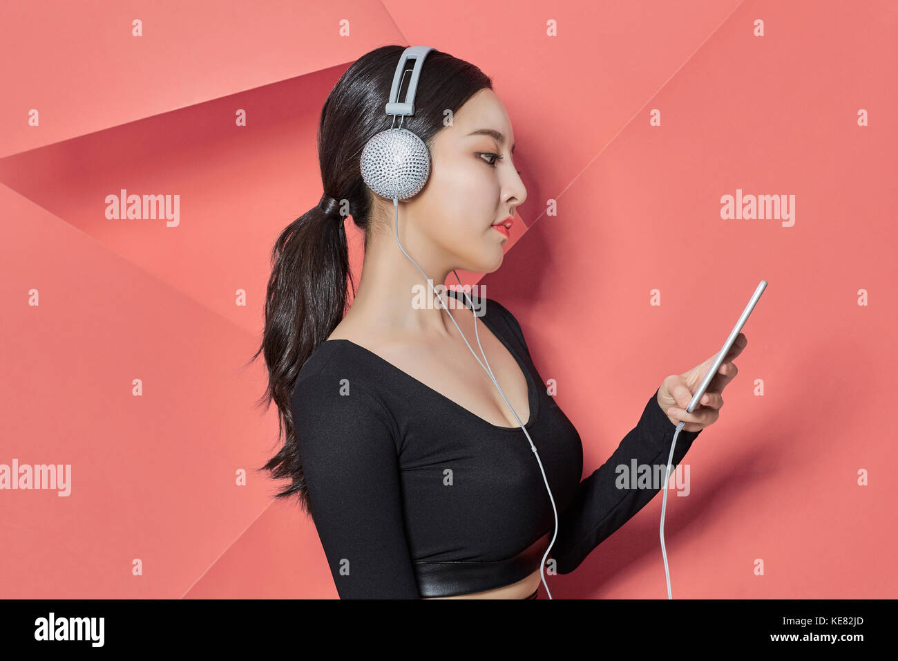 Vue de côté portrait of young woman listening to music Banque D'Images