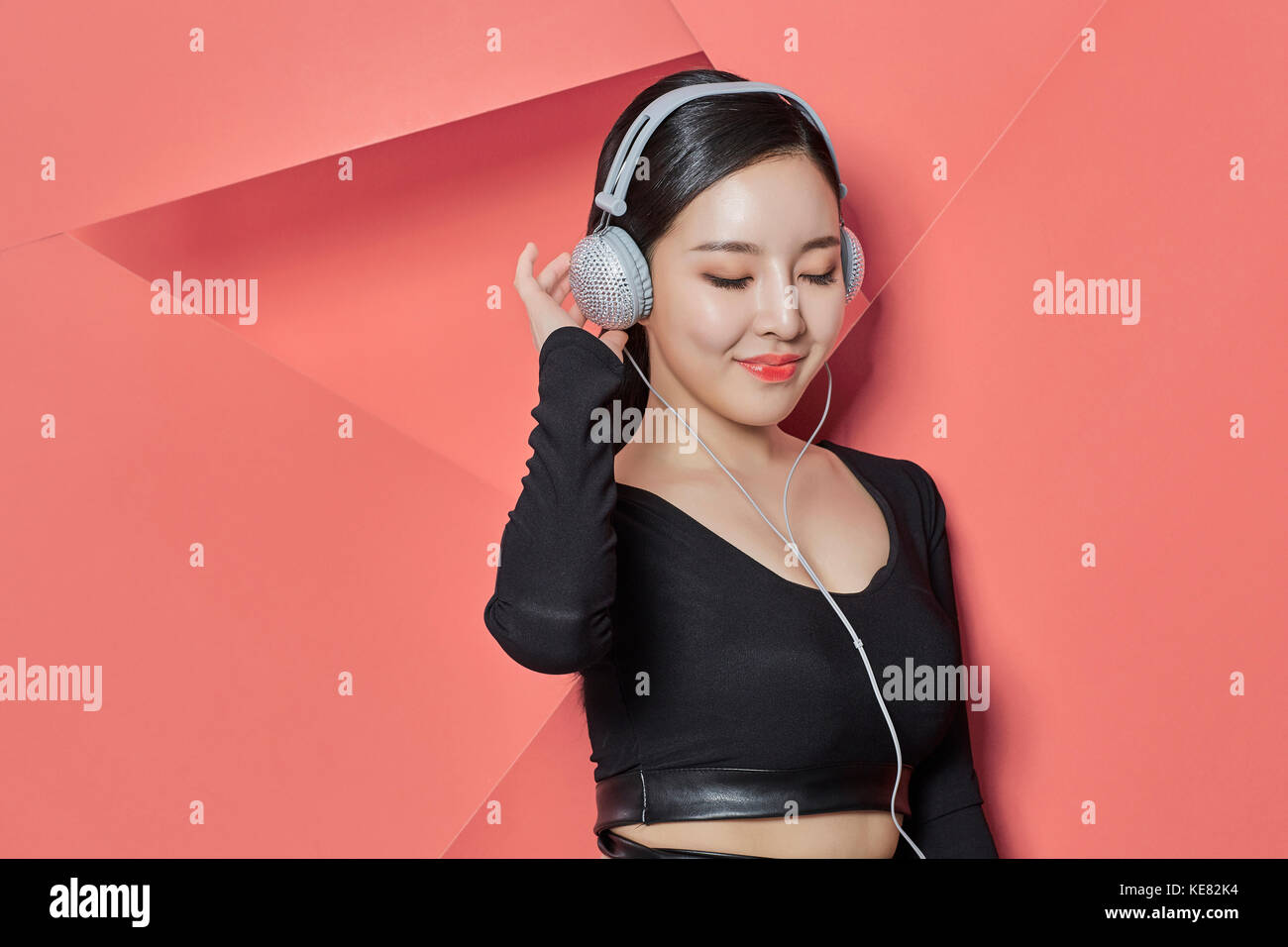 Portrait of young smiling woman listening to music Banque D'Images