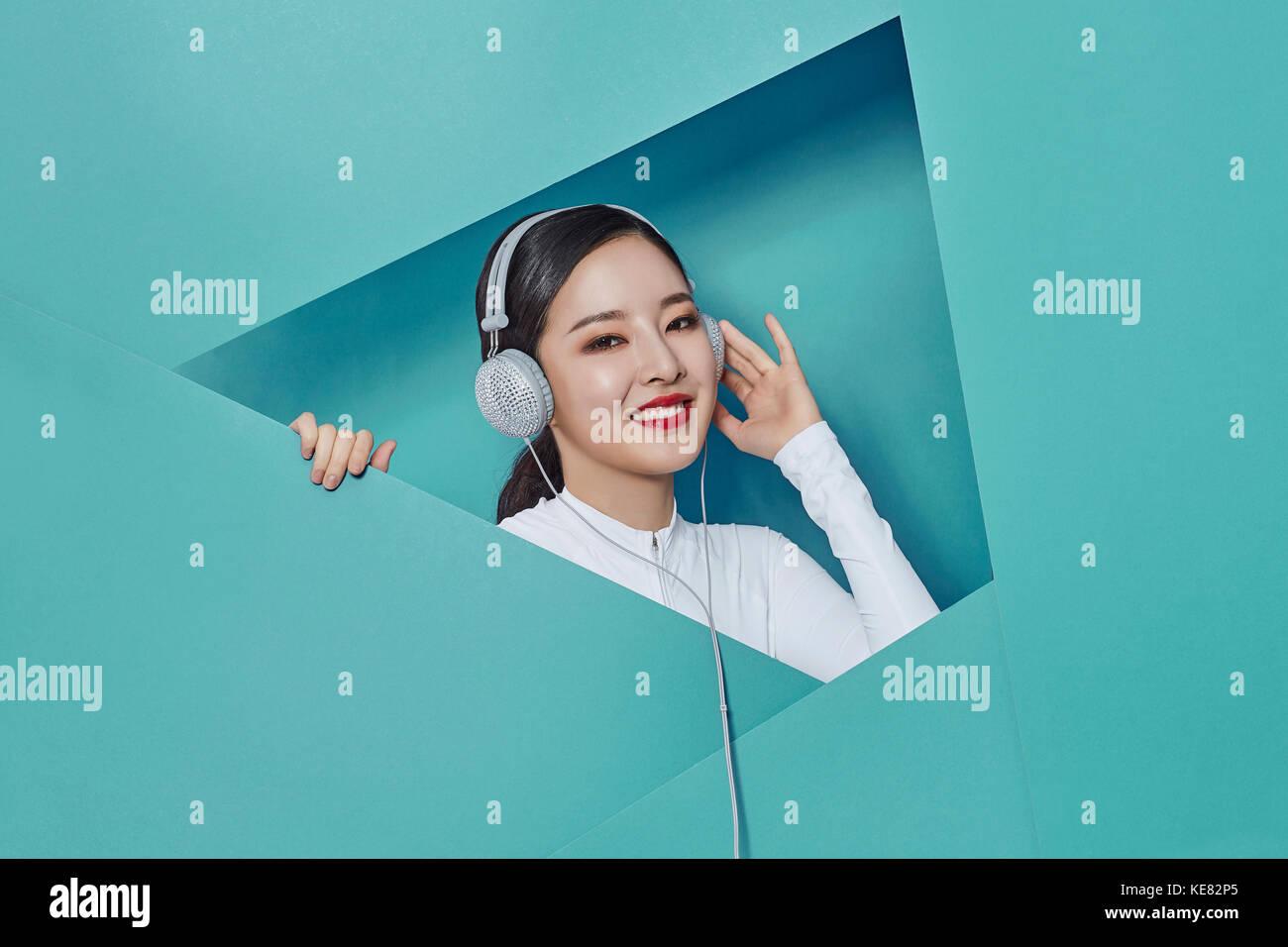 Portrait of young smiling woman listening to music Banque D'Images