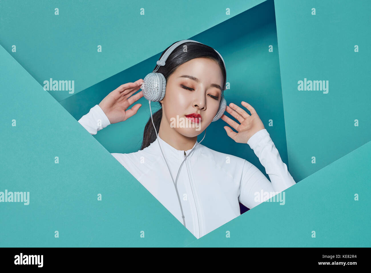 Portrait of young smiling woman listening to music fermant les yeux Banque D'Images