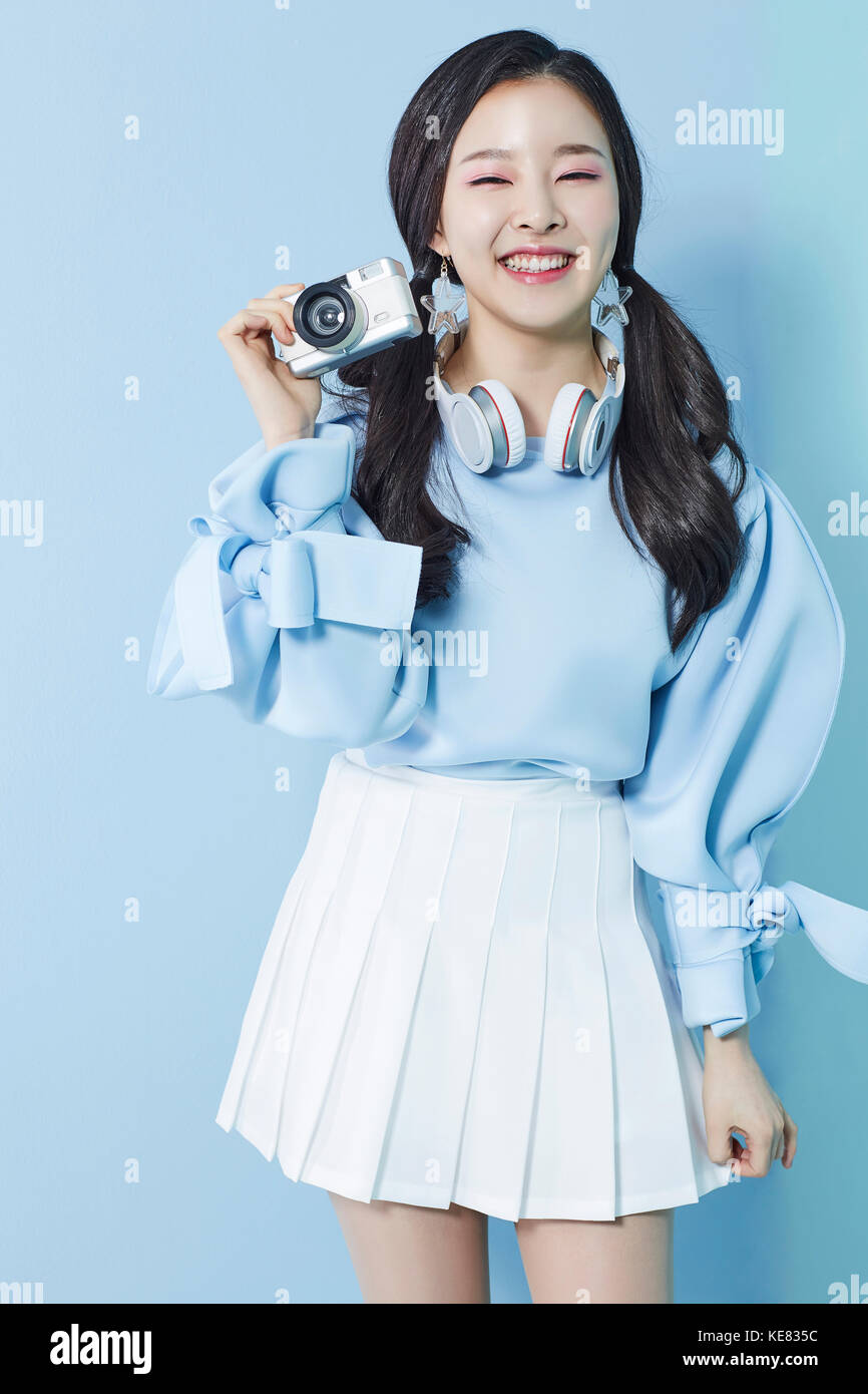Jeune femme souriante avec un appareil photo posing Banque D'Images