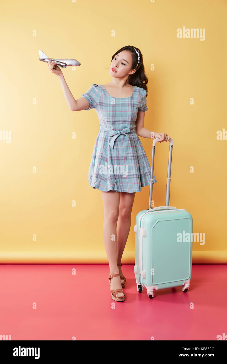 Jeune femme avec modèle réduit d'avion et d'un transporteur posing Banque D'Images